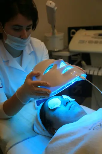 Patient receiving blue light therapy for facial treatment